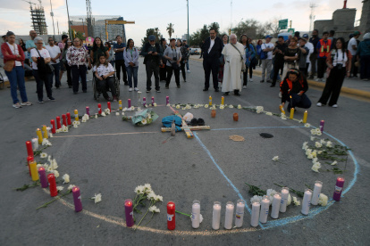 Personas se reúnen frente a un círculo de velas durante la "Vigilia por la Memoria y la Justicia" en el marco del segundo aniversario del incendio en el centro de detención migratoria que cobró la vida de 40 personas en Ciudad Juárez, Chihuahua, México, el 27 de marzo de 2025.
