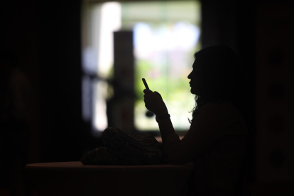 Una joven mira la pantalla de su teléfono celular, en una fotografía de archivo. EFE/ Alonso Cupul