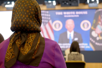 Nuevos ciudadanos observan el mensaje de felicitación del presidente en las oficinas centrales de USCIS