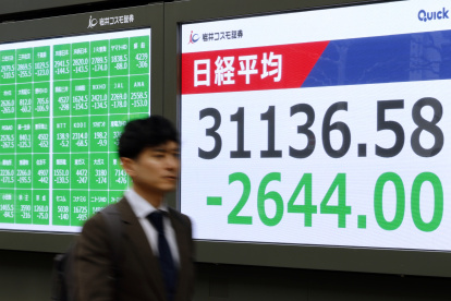 Un hombre camina junto al indicador (el Nikkei) de la Bolsa de Tokio, Japón el
 lunes 7 de abril de 2025.