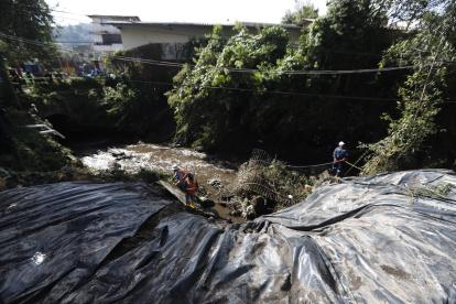 Los trabajadores municipales cubrieron parte del talud que rodea a una de las quebradas que se desbordaron por las fuertes lluvias en Quito.