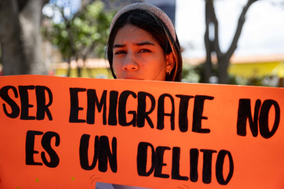 Una mujer sostiene un cartel durante una manifestación en apoyo a la migración.