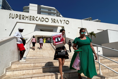 Cubanos salen del nuevo supermercado en dólares en La Habana.