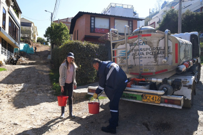 Bogotá. Clara Escobar recoge agua potable de un camión cisterna.