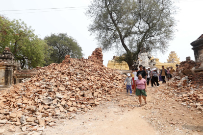 Mandalay. Varias personas caminan entre las ruinas de un monasterio que colapsó a causa del potente terremoto de hace dos semanas.