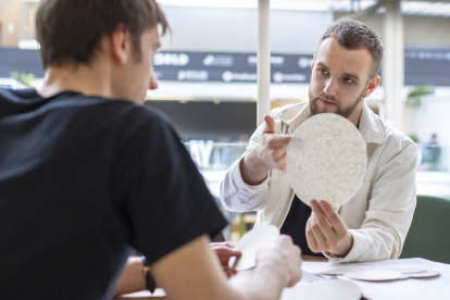 Valentyn Frechka señala un disco de papel fabricado de forma sostenible.