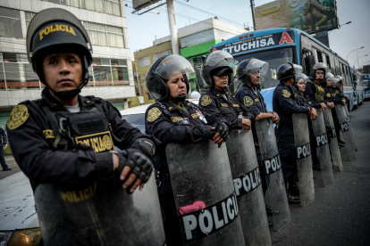 Integrantes de la Policía custodian durante una manifestación de transportistas en Lima (Perú).