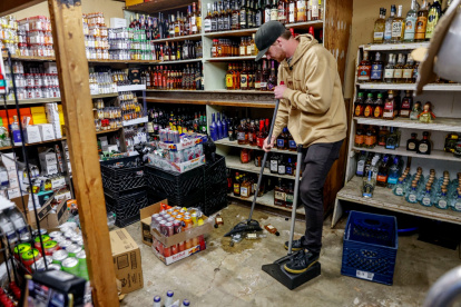 El propietario de una tienda de licores limpia los daños ocasionados por el sismo de 5,2 registrado cerca de San Diego.