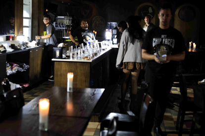 Personas atienden un bar durante un apagón este miércoles, en San Juan (Puerto Rico).