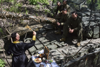 El capellán militar Serhiy celebra un servicio religioso cerca de un tanque y su tripulación durante la Pascua cerca del frente en la zona de Zaporizhzhia, Ucrania.