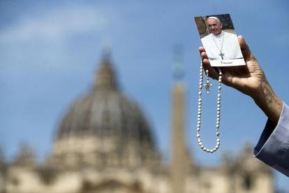Una monja muestra una foto del papa Francisco durante su rezo este lunes en la Plaza de San Pedro en el Vaticano