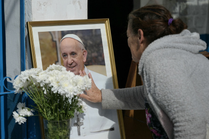 Una mujer rinde homenaje ante un retrato del difunto Papa Francisco frente a la Parroquia de Caacupé en Buenos Aires el 21 de abril de 2025.