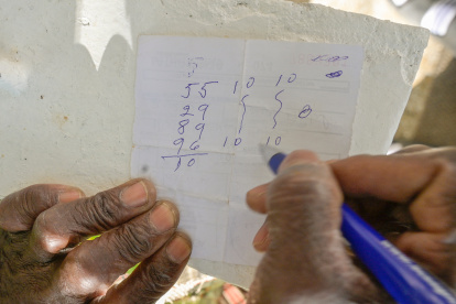 Un hombre escribe en una receta médica el dinero que jugará en Los Ángeles.