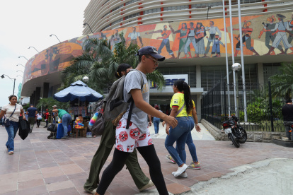Personas caminan al pie del edificio del Instituto Ecuatoriano de Seguridad Social (IESS), en Guayaquil.