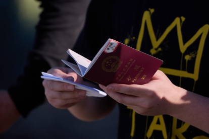 Un migrante sostiene su pasaporte para ser inspeccionado por la Patrulla Fronteriza de EE. UU.
