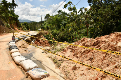 Servicio. Personas tratan de retirar lodo, piedra y otros elementos de vía.