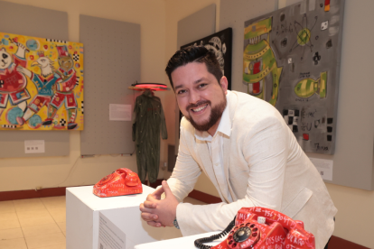 El artista posa orgulloso junto a parte de su obra.