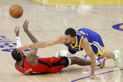 Jalen Green (i) de los Houston Rockets disputa un balón con Stephen Curry de los Warriors de Golden State.