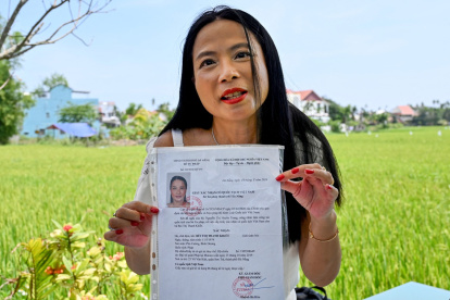 Odile Dussart, quien fue evacuada antes de que termine la guerra de Vietnam hace 50 años, muestra su certificado de nacionalidad vietnamita en su casa recién alquilada en Hoi An.