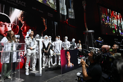 El youtuber Jimmy Zhang (derecha) está de pie en el escenario con un séquito disfrazado de esperma en el pesaje preliminar de la competencia de Sperm Racing en Los Ángeles, el 25 de abril de 2025.