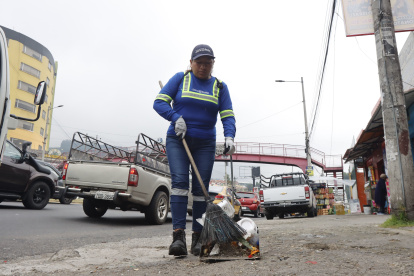 Jornada. Gloria Almache recorre más de cinco kilómetros a diario barriendo desde la Legarda y av. Mariscal Sucre, hasta el sector del colegio Los Pinos. La tarea no es sencilla por el riesgo que implica estar en una vía muy transitada, pero también por la actitud de personas que esperan que recoja la basura de su casa.