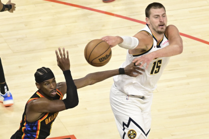 Nikola Jokic por Nuggets (d) disputa un balón ante la estrella de Thunder Shai Gilgeous-Alexander.