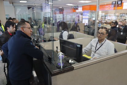 Personal del aeropuerto de Quito revisa el certificado de vacunación en el control migratorio.
