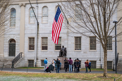 Las personas se reúnen alrededor de la estatua de John Harvard en el campus de la Universidad de Harvard en Cambridge, Massachusetts, el 15 de abril de 2025.