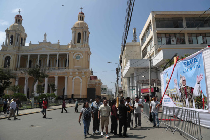 Personas pasan frente a una pancarta con la imagen del papa León XIV en la Plaza de Armas en Chiclayo (Péru). EFE/ Paolo Aguilar