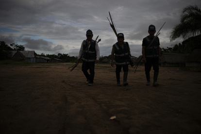 Miembros de la Guardia Indígena Shipibo Konibo caminan para participar en una reunión de coordinación antes de salir a patrullar contra los madereros ilegales en Caimito, departamento de Ucayali, Perú