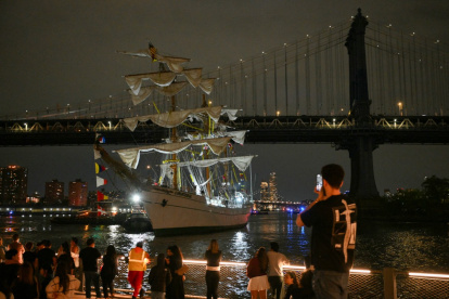Personas observan cómo un buque escuela de la Armada de México es retirado tras estrellarse contra el Puente de Brooklyn, en Nueva York, el sábado 17 de mayo de 2025.