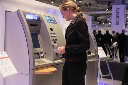Una persona utiliza un cajero para realizar una transacción bancaria.