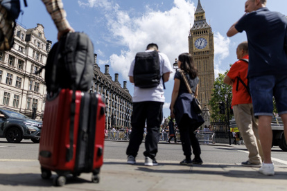 Una persona carga una maleta con la Torre Isabelina, comúnmente conocida como Big Ben, al fondo, en Parliament Square, Londres, Reino Unido, 12 de mayo de 2025.