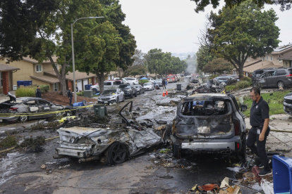 Los investigadores examinan el lugar donde una avioneta se estrelló en una calle residencial de San Diego, California, el 22 de mayo de 2025.