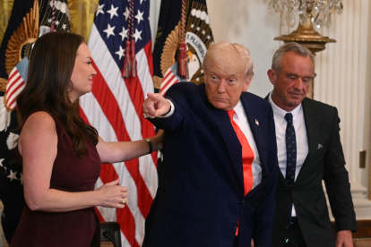 El presidente Donald Trump hace un gesto junto a la secretaria de Agricultura, Brooke Rollins, y el secretario de Salud y Servicios Humanos, Robert F. Kennedy Jr.