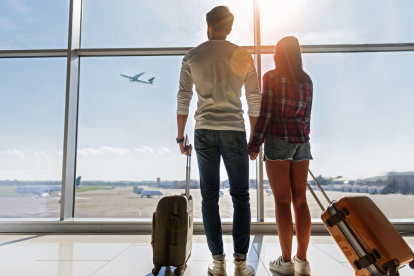 Referencial. Pareja esperando su vuelo en aeropuerto.