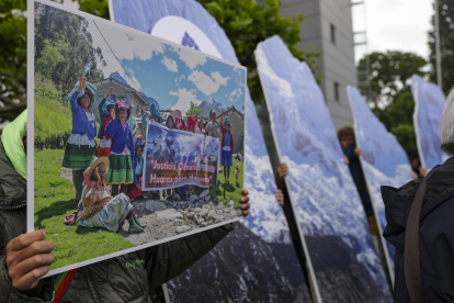 Un activista de la organización ambiental alemana Germanwatch sostiene una foto de activistas persas ante el Tribunal Regional Superior antes de la sentencia en Hamm, Alemania Occidental, el 28 de mayo de 2025.