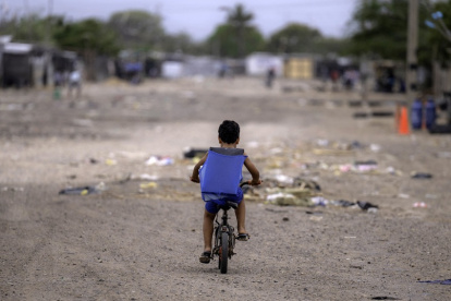Un niño migrante venezolano monta su bicicleta en el campamento de migrantes La Pista en Maicao, departamento de La Guajira, Colombia, el 22 de abril de 2025.