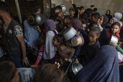 Cientos de palestinos se amontonan frente al Comedor Social Sokar en la Ciudad de Gaza para conseguir raciones de comida.