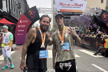 El luchador ecuatoriano Chito Vera y el baterista Travis Barker celebran tras completar juntos la maratón en San Diego