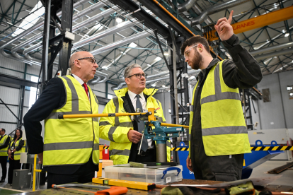 El primer ministro británico, Keir Starmer (centro), y el secretario de Defensa británico, John Healey (izq.), conversan con un miembro del personal durante una visita a las instalaciones de Govan de BAE Systems en Glasgow, el 2 de junio de 2025.