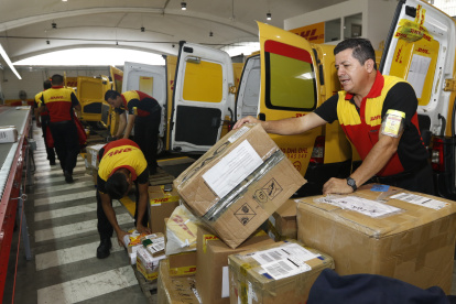 Personas trabajan en una empresa que ofrece el servicio de entrega de paquetes en casa.