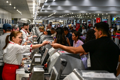 Los viajeros entregan documentos al personal de la aerolínea en el Aeropuerto Internacional de Miami durante el 24 de mayo de 2025 en Miami, Florida.