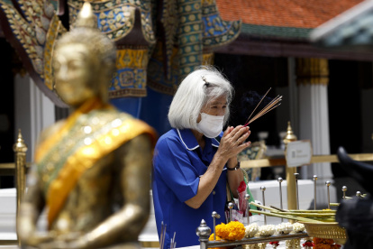 Una mujer usando mascarilla durante una visita a un sitio budista en Bangkok, Tailandia.
