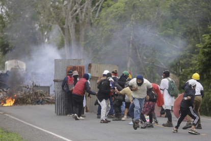 Personas se enfrentan con integrantes de la Policía de Panamá, durante una manifestación contra la reforma a la seguridad social este jueves, en Arimae (Panamá).