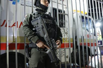 Un policía custodia frente a la ambulancia en la que es trasladado el senador colombiano Miguel Uribe Turbay este sábado, en Bogotá (Colombia).