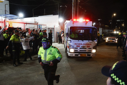 Policías custodian la ambulancia en la que es trasladado el senador Miguel Uribe Turbay, este sábado, en Bogotá (Colombia).