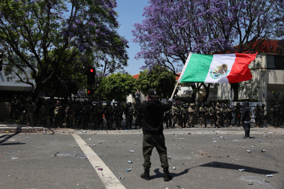 Protestante sostiene bandera mexicana en California.