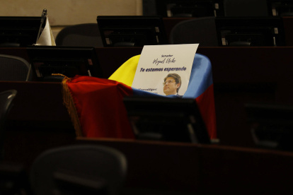 Fotografía de la curúl del senador Miguel Uribe Turbay cubierta con la bandera de Colombia este lunes, en Bogotá (Colombia).