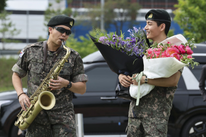 RM toca el saxofón junto a su compañero de banda V, mientras sus fans disfrutan de su salida, luego de completar 18 meses de servicio militar obligatorio.